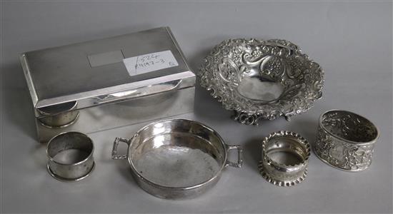 A silver cigarette box, a Victorian bon bon dish, three napkin rings and another dish.